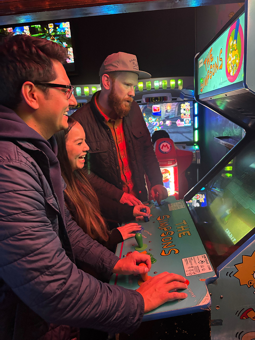 teammates playing an arcade game together