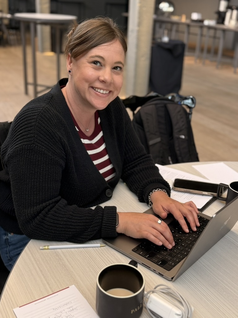 teammate working on a laptop over morning coffee