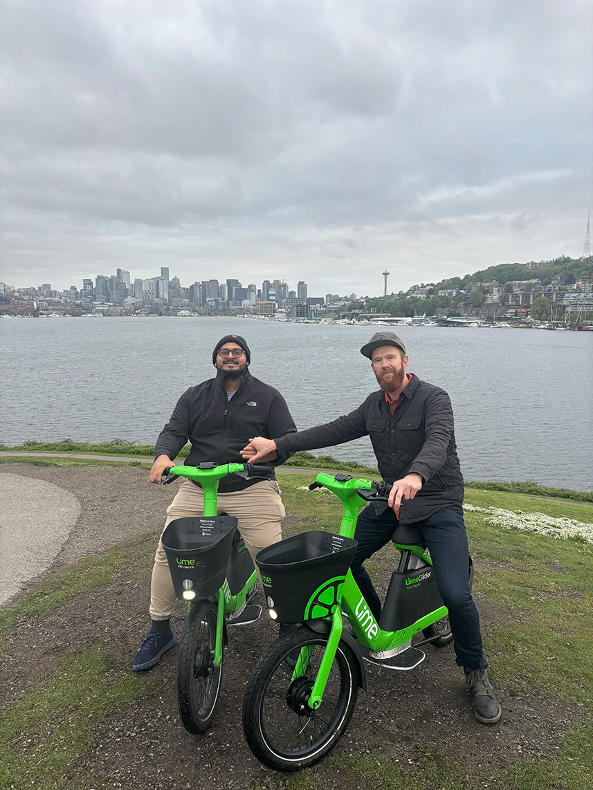 teammates biking along Seattle's Lake Union with the skyline in the background